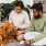 a man and a woman sitting on the floor with a dog