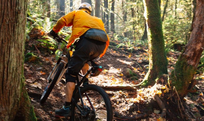 Settle into comfort at Topograph a man riding a bike through the woods