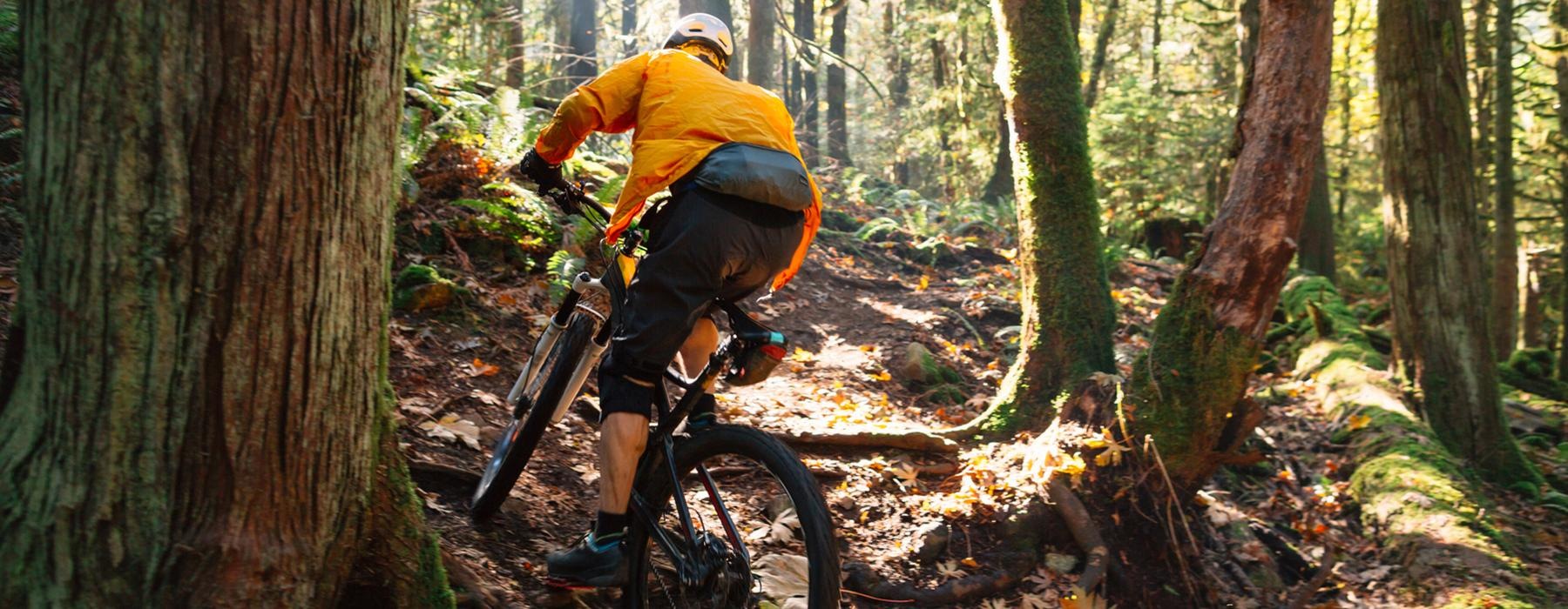 a man riding a bike through the woods